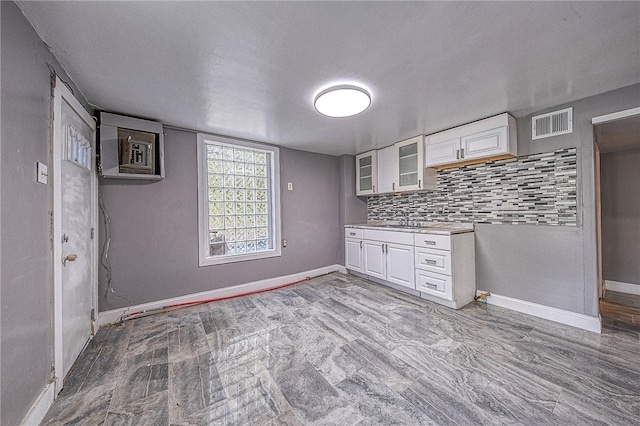 kitchen featuring decorative backsplash and white cabinetry