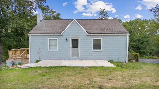 rear view of house featuring a patio and a lawn