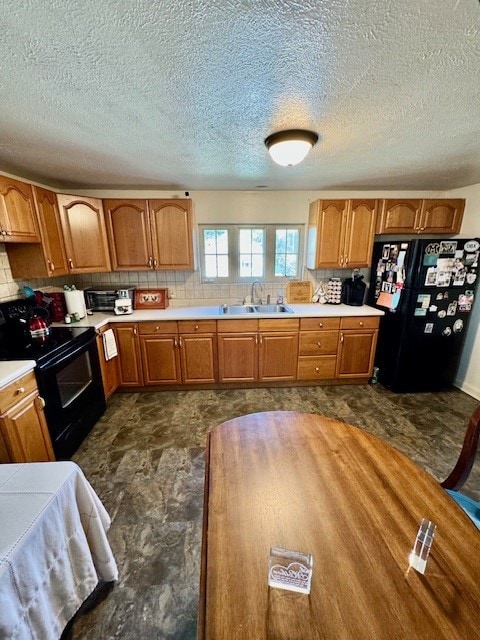 kitchen featuring a textured ceiling, black appliances, dark tile patterned floors, sink, and decorative backsplash