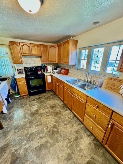 kitchen with black electric range, sink, a textured ceiling, and light tile patterned flooring