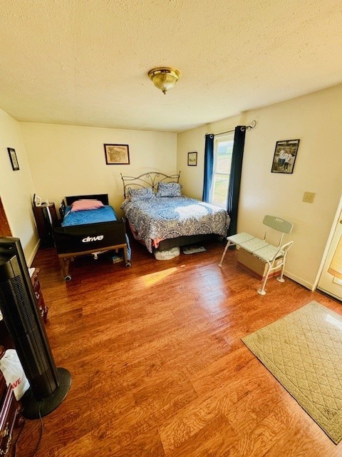 bedroom with a textured ceiling and hardwood / wood-style floors