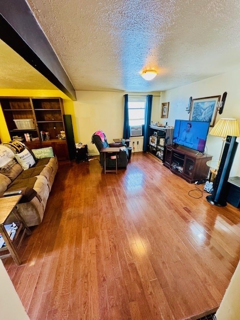 living room featuring a textured ceiling and wood-type flooring