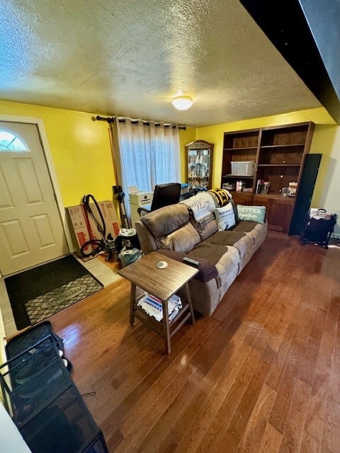 living room with a textured ceiling and wood-type flooring