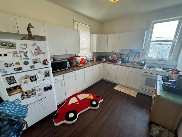 kitchen with sink, white appliances, white cabinetry, and dark hardwood / wood-style floors