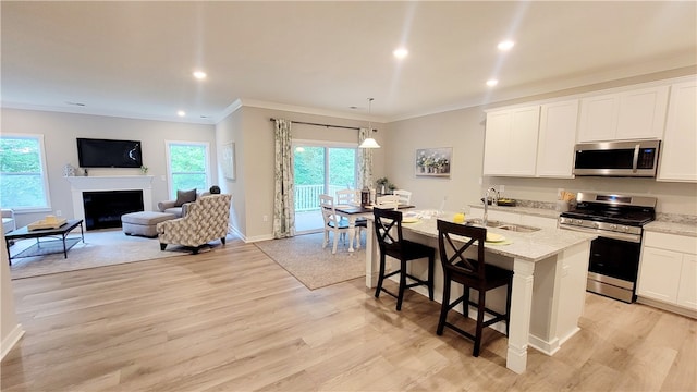 kitchen with light hardwood / wood-style floors, appliances with stainless steel finishes, and sink