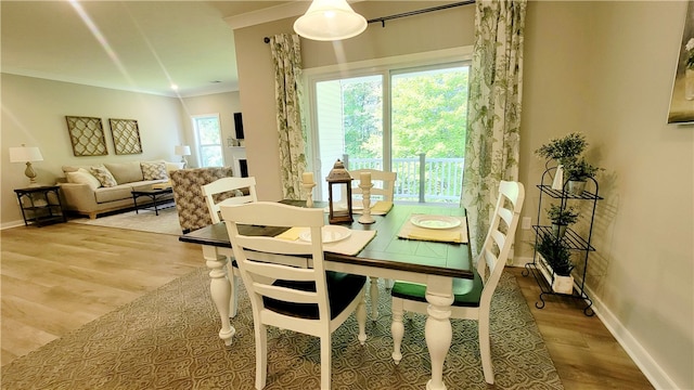 dining area featuring light hardwood / wood-style floors and ornamental molding