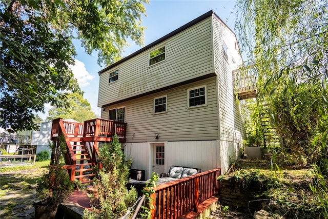 rear view of house featuring a wooden deck