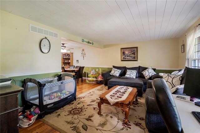 living room with light hardwood / wood-style flooring and ceiling fan