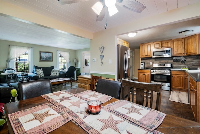 tiled dining space with sink, beam ceiling, and ceiling fan