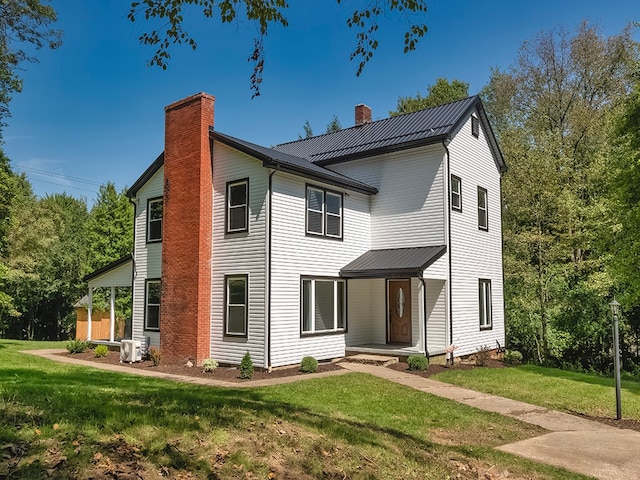 view of front of property with cooling unit and a front lawn