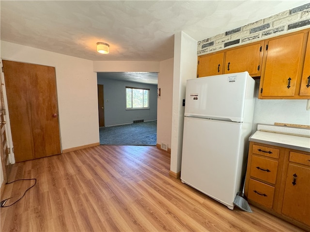 kitchen featuring light hardwood / wood-style floors and white fridge