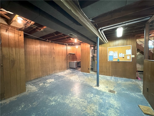 basement featuring wood walls