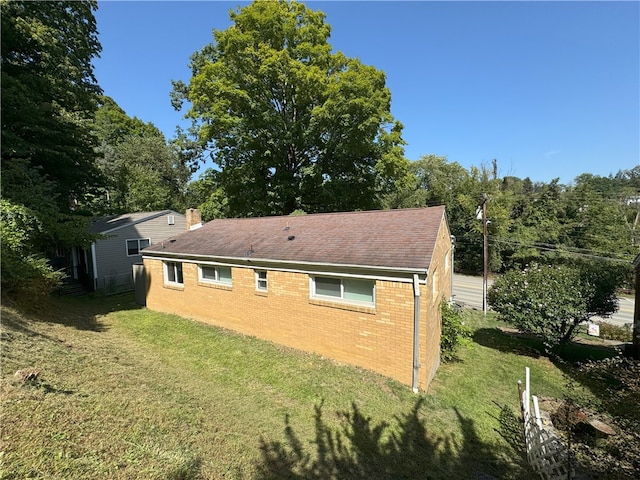 back of property featuring brick siding and a yard