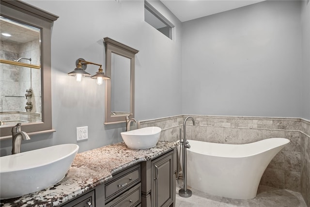 bathroom featuring vanity, tile walls, and plus walk in shower