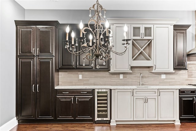 bar featuring backsplash, dark hardwood / wood-style flooring, beverage cooler, and sink