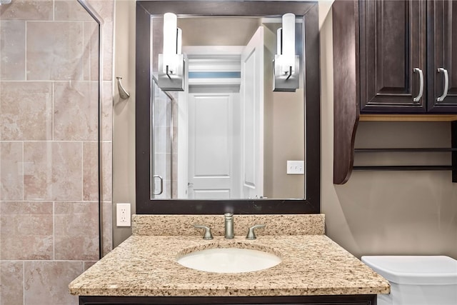 bathroom featuring vanity, toilet, and walk in shower