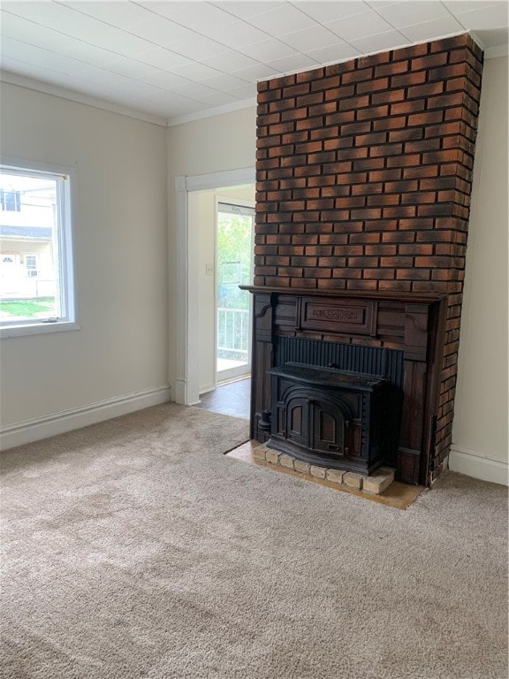 unfurnished living room with a wealth of natural light, crown molding, and brick wall