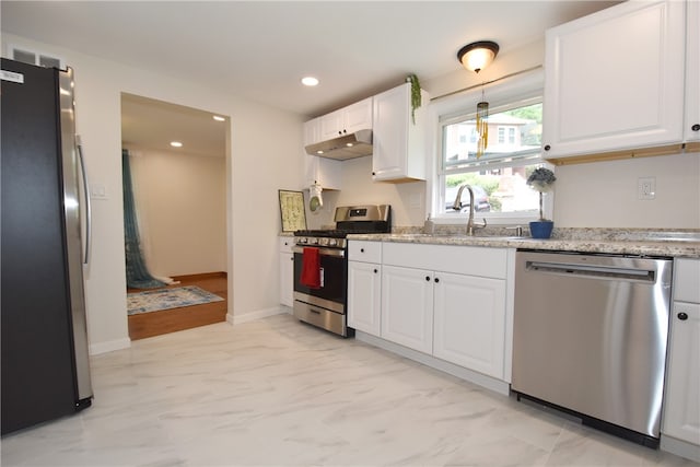 kitchen featuring appliances with stainless steel finishes, light stone counters, light tile patterned floors, and sink