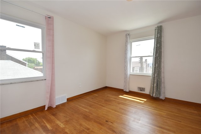 spare room with wood-type flooring and a wealth of natural light