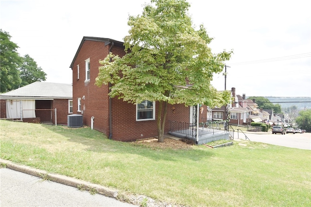 view of side of home with a lawn and central air condition unit