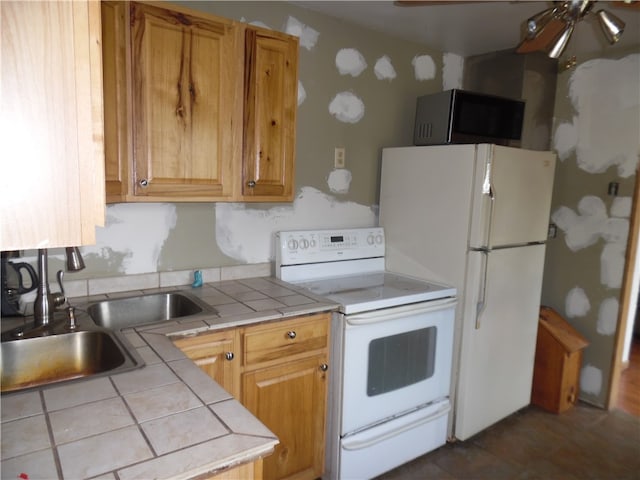 kitchen with dark tile patterned floors, white appliances, sink, ceiling fan, and tile counters