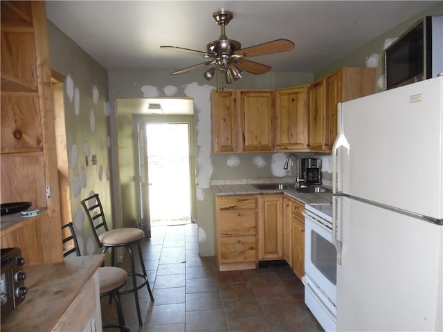 kitchen with ceiling fan, sink, tile countertops, and white appliances