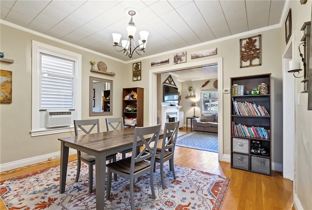 dining room with crown molding, a healthy amount of sunlight, a notable chandelier, and light hardwood / wood-style floors