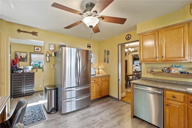 kitchen featuring light wood-type flooring, ceiling fan with notable chandelier, and stainless steel appliances