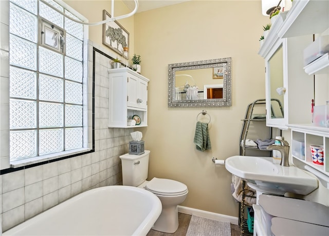 bathroom with tile walls, toilet, a bathing tub, and tile patterned floors