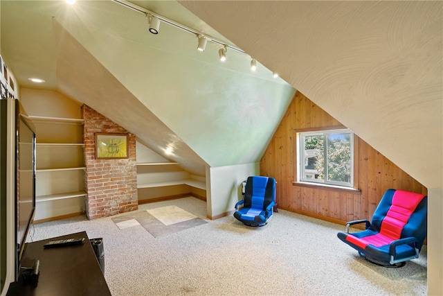 additional living space featuring lofted ceiling, carpet flooring, brick wall, and wooden walls