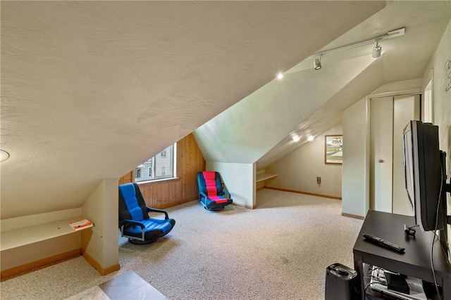 bonus room with a textured ceiling, lofted ceiling, and carpet floors