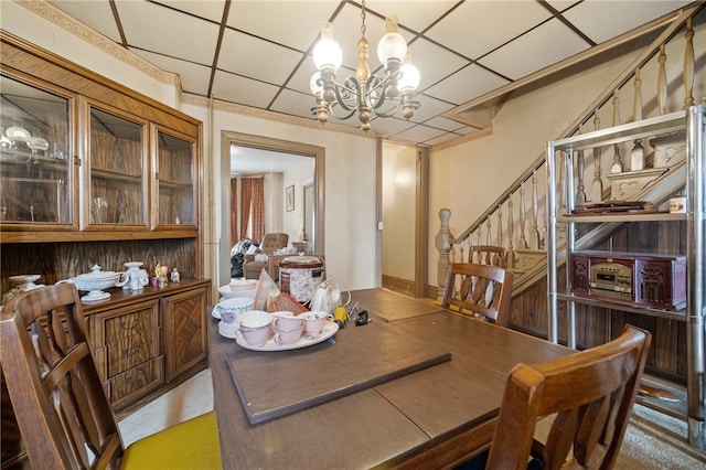 dining area with a notable chandelier and a drop ceiling