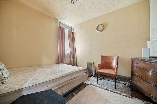 bedroom with a textured ceiling and radiator