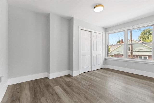 unfurnished bedroom with hardwood / wood-style flooring and a closet