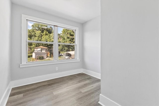 empty room featuring wood finished floors and baseboards