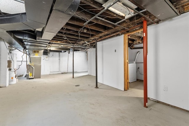 basement featuring heating unit and washer / clothes dryer