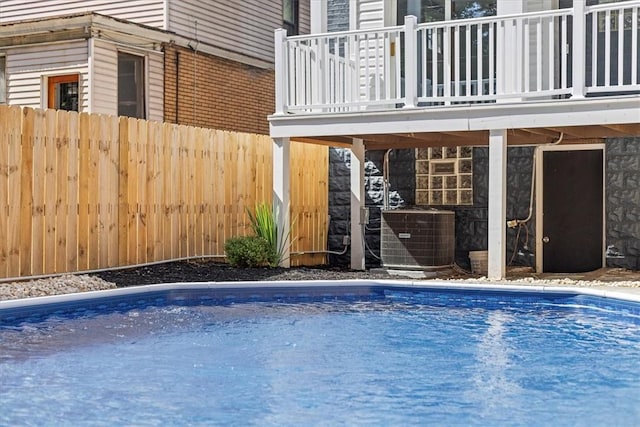 view of swimming pool featuring a fenced in pool, central AC, and fence