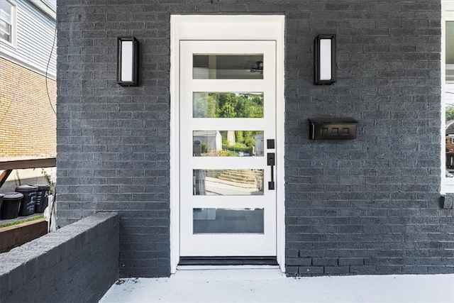 doorway to property with brick siding