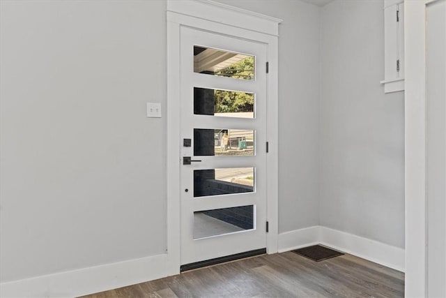 doorway featuring wood finished floors, visible vents, and baseboards