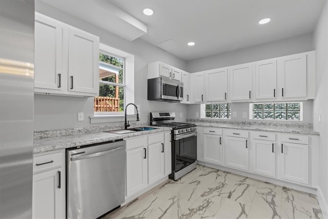 kitchen featuring sink, white cabinetry, appliances with stainless steel finishes, and light tile patterned flooring