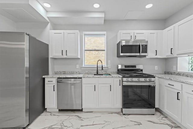 kitchen with white cabinetry, appliances with stainless steel finishes, a sink, and recessed lighting