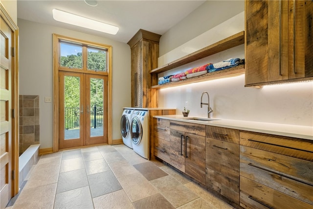 clothes washing area featuring sink, washing machine and dryer, french doors, and light tile patterned floors