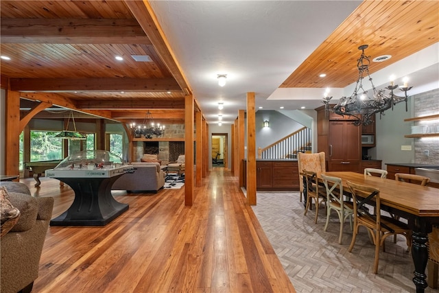 dining area with beamed ceiling, light hardwood / wood-style floors, a notable chandelier, and wooden ceiling