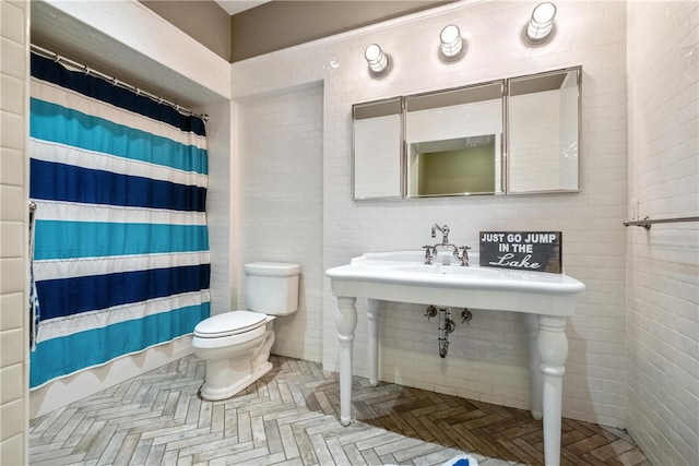 bathroom featuring tile walls, toilet, and a shower with shower curtain