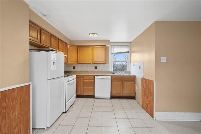 kitchen with sink, white appliances, decorative backsplash, and light tile patterned floors