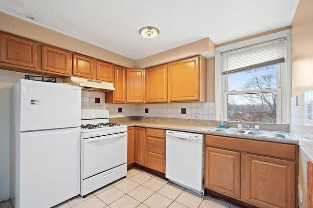 kitchen featuring light tile patterned floors, backsplash, sink, and white appliances