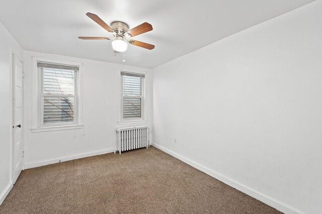 unfurnished room with ceiling fan, radiator heating unit, and carpet flooring