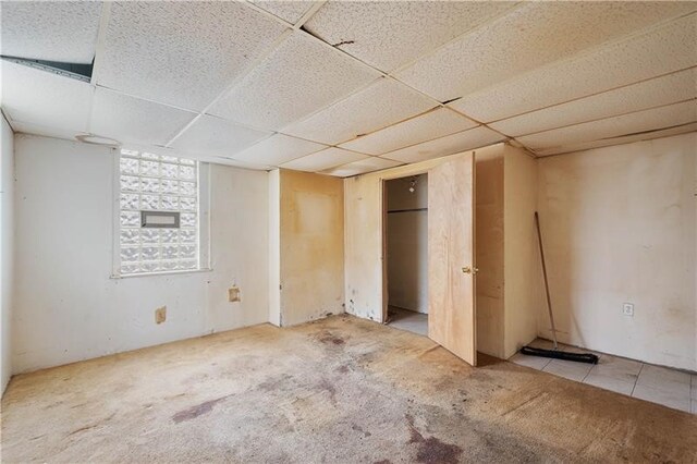 unfurnished bedroom with carpet and a drop ceiling