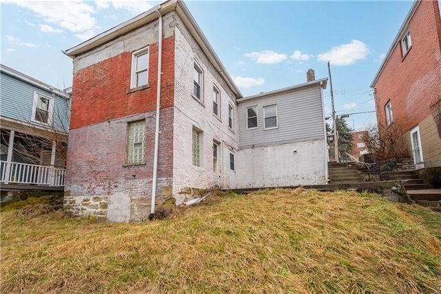 rear view of property featuring a lawn