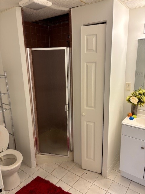 bathroom featuring tile patterned flooring, toilet, vanity, and walk in shower